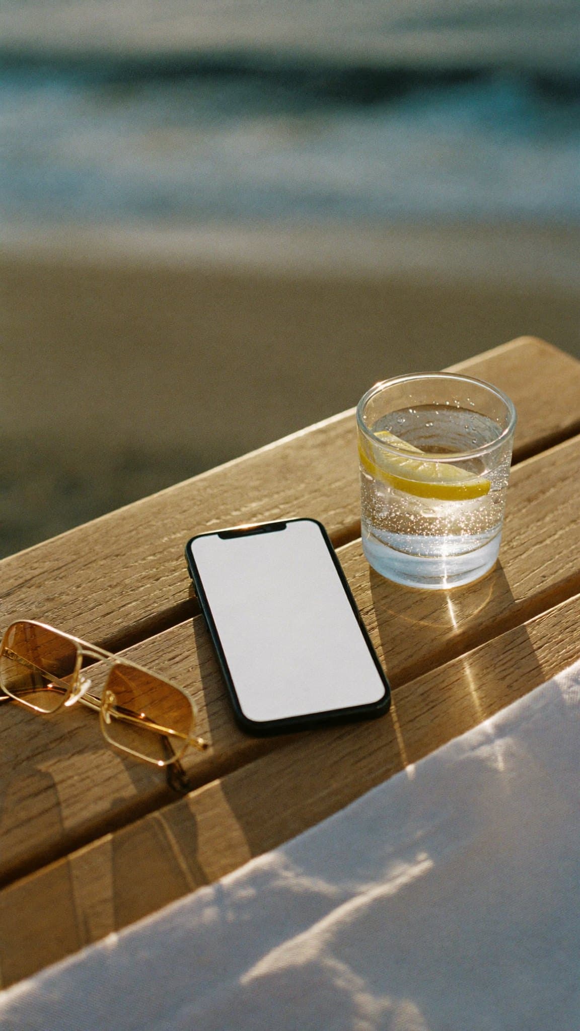 A phone lying on a sunlit table with a new message nobody has opened